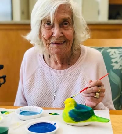 Resident painting a decorative bird in a common area