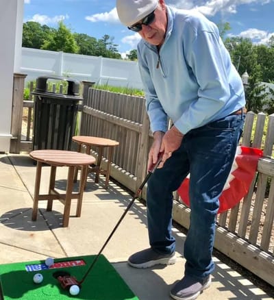 Resident practicing golf on outdoor putting green