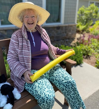 Resident enjoying outdoor time with a pool noodle