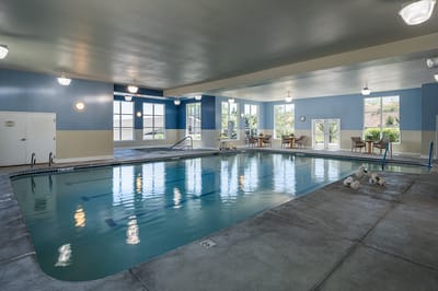 Indoor pool area with seating and natural light