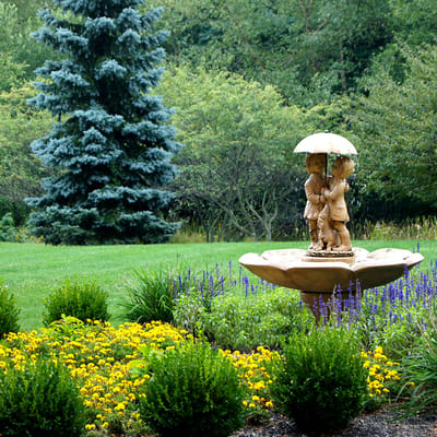 Garden fountain surrounded by colorful flowers