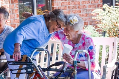 Two smiling seniors sharing a joyful moment outdoors