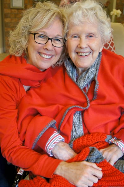A smiling woman and resident posing together warmly