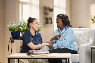 Staff member engaging with a resident in a cozy common area