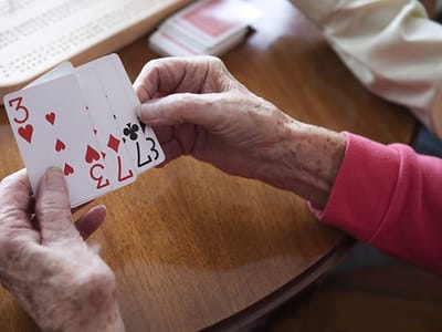 Close-up of hands playing cards at a table