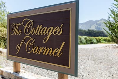 Sign for The Cottages of Carmel with a scenic background