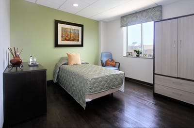A cozy resident room with a bed and window