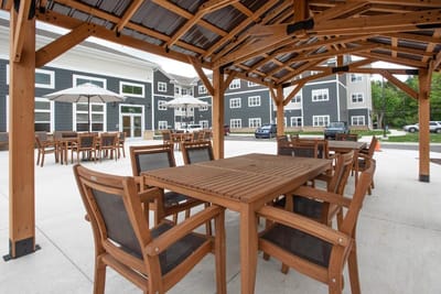 Outdoor seating area with a wooden gazebo and tables