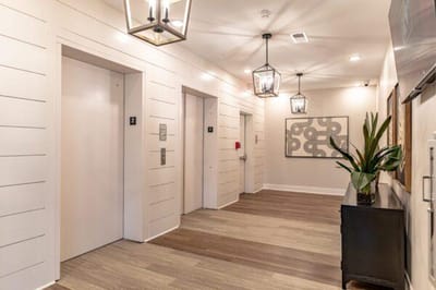 Interior corridor with elevators and modern lighting