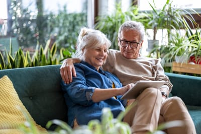 Couple enjoying time together on a couch with a tablet