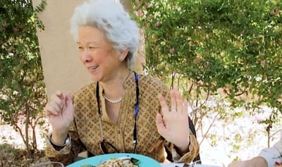 Resident enjoying a meal outdoors with a smile