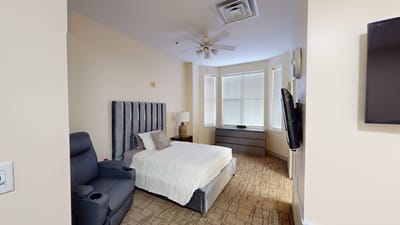 Cozy resident room with bed and chair