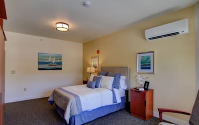 Brightly decorated resident room with a bed and art
