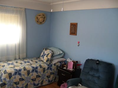 Cozy resident room with a bed and chair