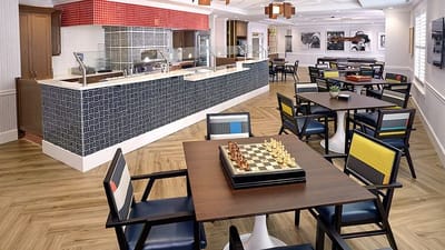 Well-lit dining area with chairs and chess set