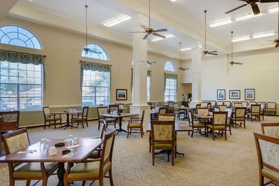 Bright dining room with tables and chairs set up
