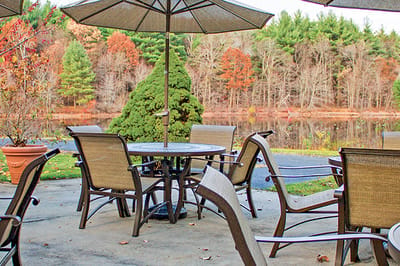 Outdoor seating area by a tranquil pond
