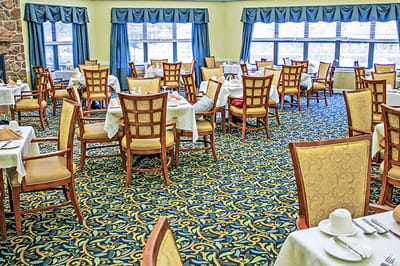 Brightly lit dining room setup with tables and chairs