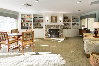 Bright common area with bookshelves and fireplace