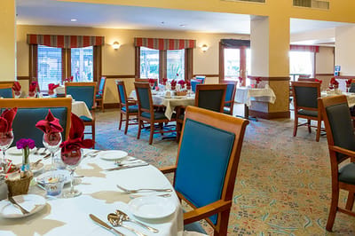 Dining room set for a meal with flowers on the tables