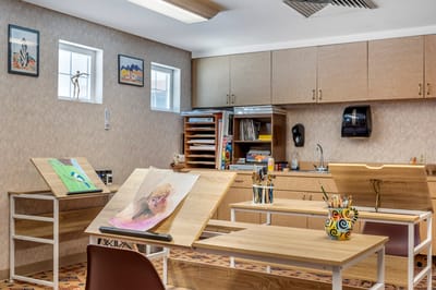 Art room with easels and supplies for resident activities