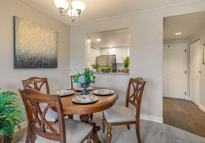 A dining area with a wooden table and chairs