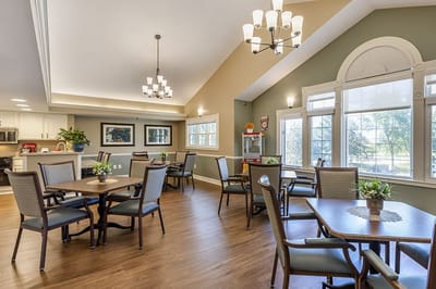 Bright common area with tables and chairs for residents