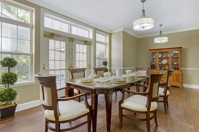 Bright, nicely set dining room with a table and chairs