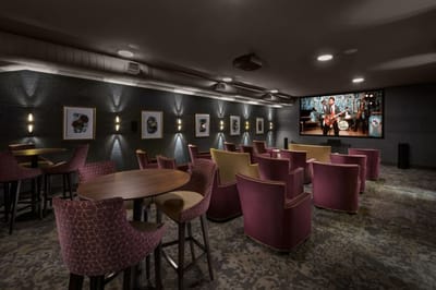 A cozy common area with seating and a large screen
