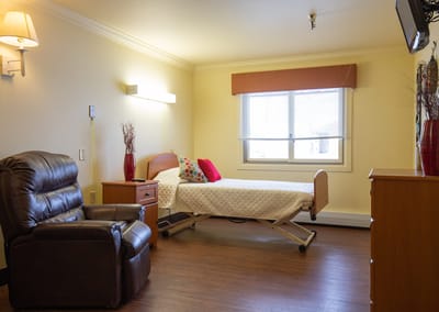 Cozy resident room with a bed and chair