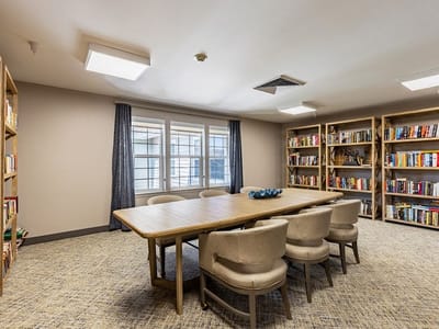 Bright common area with bookshelves and a large table