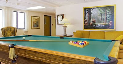Billards table in a common area with a cozy seating
