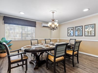 A dining room with a large table, chairs, and decor
