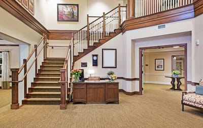 Bright interior lobby with a staircase and reception area