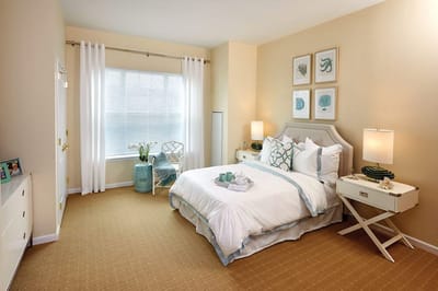 Brightly decorated resident room with bed and furniture