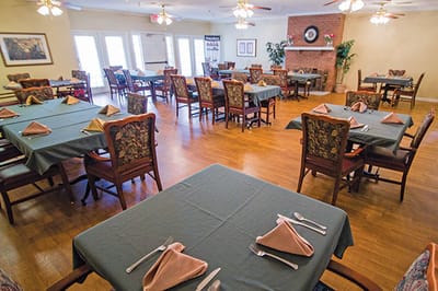 Dining room setup with tables and chairs ready for residents