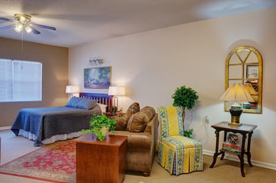 Cozy interior of a resident room with a bed and seating area