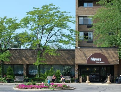 Residents enjoying the outdoor space by the building entrance