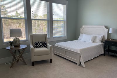Bright private bedroom with a bed and chair
