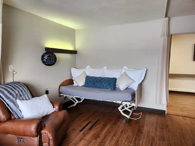 A well-furnished resident room with a hospital bed