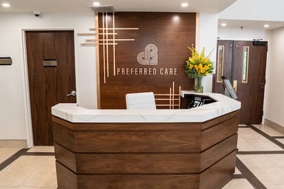 Reception area at Preferred Care with flowers and logo