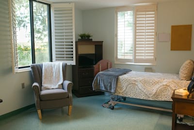 Private resident room with a bed and chair