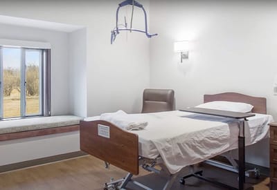 Private resident room with a hospital bed and window view