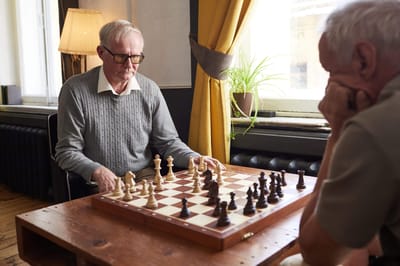 Two residents playing chess in a common area