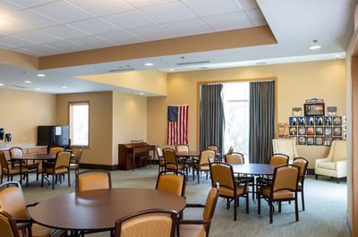 Common area with tables and chairs in a light-filled room