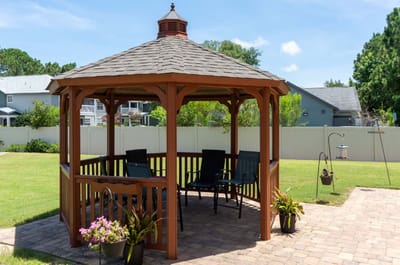 A gazebo in a green outdoor space with seating
