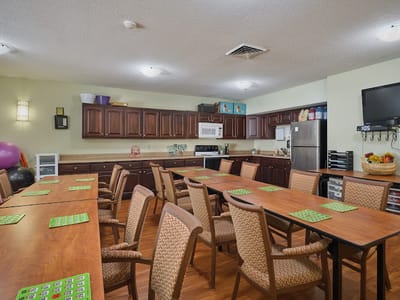 Bright common area with tables and chairs set up for activities