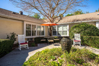 Outdoor seating area with a fountain and orange umbrella