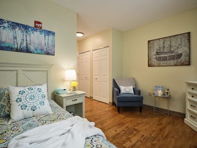Cozy resident room with a bed and armchair