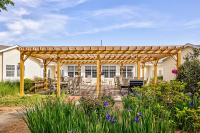 Outdoor patio area with seating and vibrant flowers